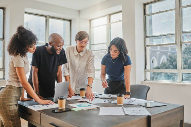 Project management, documents or business meeting with paper charts, analytics and marketing strategy or KPI planning. Leader, team or collaboration in office for diversity, B2B sales or company data